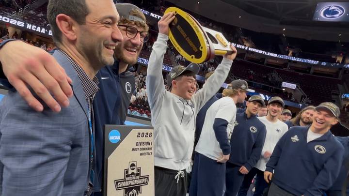 Penn State wrestler Masanosuke Ono lifts the championship trophy at the NCAA Wrestling Championships at Rocket Arena.