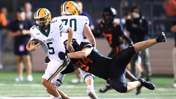 St. Edward quarterback scrambles as Massillon defender tries to bring him down during action Friday night, September 19, 2025 at Paul Brown Tiger Stadium. 