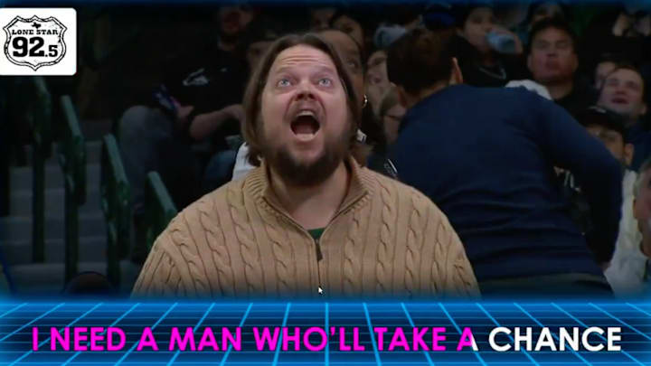 A Mavericks fan makes his voice heard by mouthing “fire Nico” during a karaoke performance.