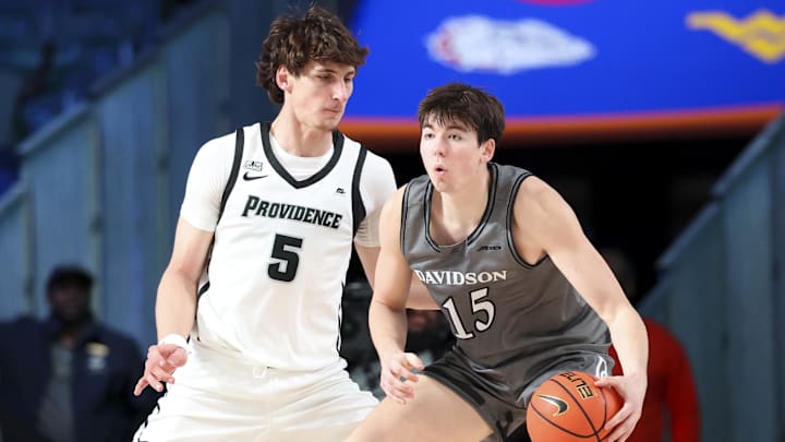 Nov 28, 2024;  Paradise Island, Bahamas, BHS; Davidson Wildcats forward Sean Logan (15) dribbles as Providence Friars center Anton Bonke (5) defends during the first half at the Imperial Arena at the Atlantis Resort.  Mandatory Credit: Kevin Jairaj-Imagn Images