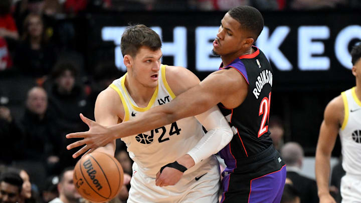 Mar 7, 2025; Toronto, Ontario, CAN;  Utah Jazz center Walker Kessler (24) looks to make a pass as Toronto Raptors center Orlando Robinson (21) defends in the first half at Scotiabank Arena. Mandatory Credit: Dan Hamilton-Imagn Images
