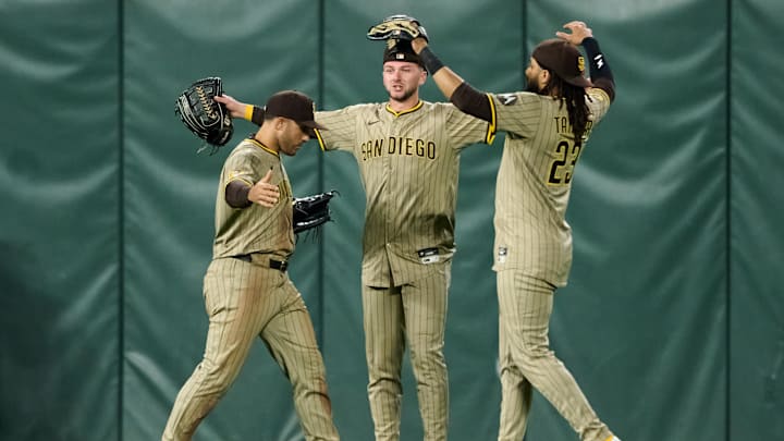 Aug 12, 2025; San Francisco, California, USA; San Diego Padres outfielders Ramon Laureano (5) (left), Jackson Merrill (3) (center) and Fernando Tatis Jr. (23) celebrate after defeating the San Francisco Giants in the ninth inning at Oracle Park. Mandatory Credit: Robert Edwards-Imagn Images