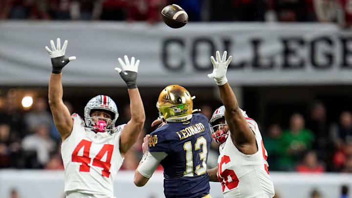 Notre Dame Fighting Irish quarterback Riley Leonard (13) throws the ball against Ohio State Buckeyes defensive end JT Tuimoloau (44) and Ohio State Buckeyes defensive end Eddrick Houston (96) in the fourth quarter during the College Football Playoff National Championship at Mercedes-Benz Stadium in Atlanta on January 20, 2025.