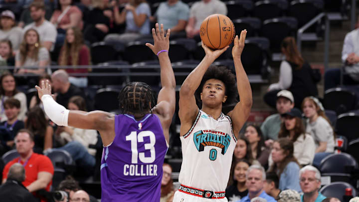 Mar 25, 2025; Salt Lake City, Utah, USA;  Memphis Grizzlies forward Jaylen Wells (0) shoots the ball over Utah Jazz guard Isaiah Collier (13) during the second half at Delta Center. Mandatory Credit: Chris Nicoll-Imagn Images