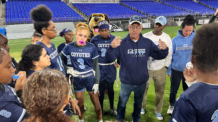 Clarksburg girls flag football head coach K.C. Landefeld speaks with his team during halftime of Friday's state championship game at M&T Bank Stadium.