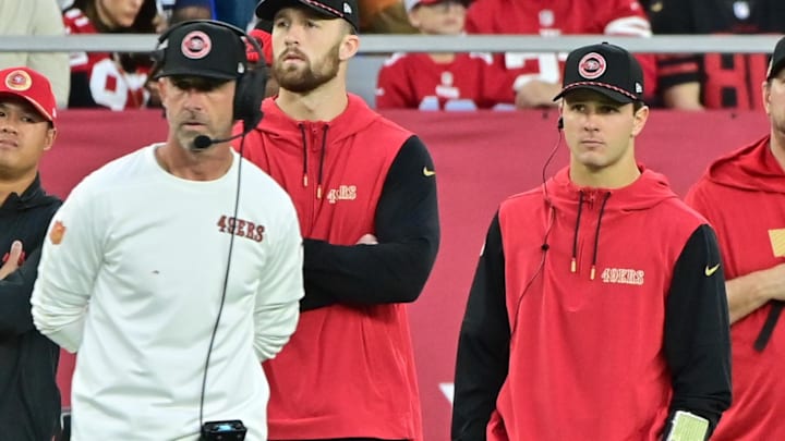 Jan 5, 2025; Glendale, Arizona, USA;  San Francisco 49ers quarterback Brock Purdy (right) and head coach Kyle Shanahan (left) look on the in second half against the Arizona Cardinals at State Farm Stadium. Mandatory Credit: Matt Kartozian-Imagn Images