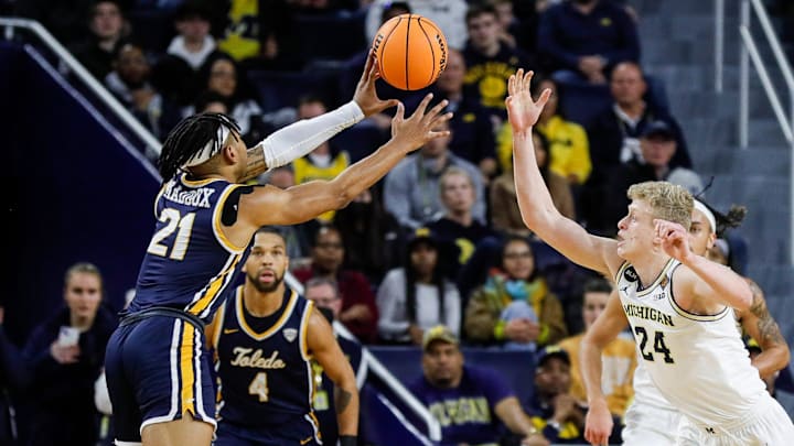 Toledo guard Dante Maddox Jr. (21) makes a pass against Michigan forward Youssef Khayat (24) 