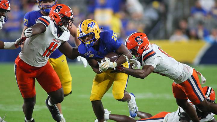 Pittsburgh Panthers running back Damon Ferguson Jr. (26) attempts to slip away from Syracuse Orange defensive back Chris Peal (12) after finding a hole in the Syracuse Orange defensive line during the second half at Acrisure Stadium in Pittsburgh, PA on September 17, 2026. Pittsburgh Panthers running back Damon Ferguson Jr. (26) attempts to slip away from Syracuse Orange defensive back Chris Peal (12) after finding a hole in the Syracuse Orange defensive line during the second half at Acrisure Stadium in Pittsburgh, PA on September 17, 2026.
