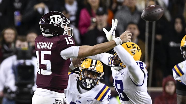 Nov 26, 2022; College Station, Texas, USA; Texas A&M Aggies quarterback Conner Weigman (15) passes for a touchdown over LSU Tigers defensive end BJ Ojulari (18) during the second quarter at Kyle Field. Mandatory Credit: Jerome Miron-Imagn Images