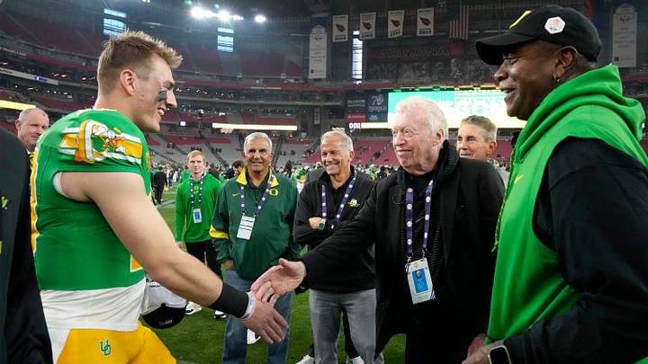 Oregon Ducks quarterback Bo Nix greets Phil Knight after defeating the Liberty Flames to win the Fiesta Bowl at State Farm Stadium in Glendale on Jan. 1, 2024.