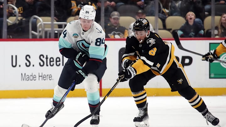 Jan 14, 2025; Pittsburgh, Pennsylvania, USA;  Seattle Kraken right wing Kaapo Kakko (84) skates with the puck as Pittsburgh Penguins left wing Michael Bunting (8) chases during the third period at PPG Paints Arena. Mandatory Credit: Charles LeClaire-Imagn Images