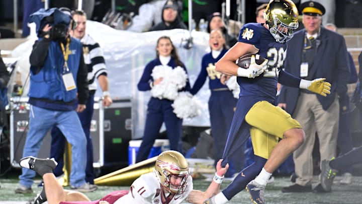 Nov 9, 2024; South Bend, Indiana, USA;  Notre Dame Fighting Irish safety Luke Talich (28) scores after an interception against Florida State Seminoles quarterback Brock Glenn (11) in the fourth quarter at Notre Dame Stadium. Mandatory Credit: Matt Cashore-Imagn Images