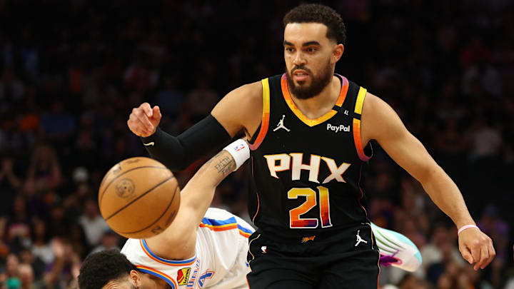 Apr 9, 2025; Phoenix, Arizona, USA; Phoenix Suns guard Tyus Jones (21) dribbles around Oklahoma City Thunder forward Adam Flagler (14) during the first half at Footprint Center. Mandatory Credit: Mark J. Rebilas-Imagn Images