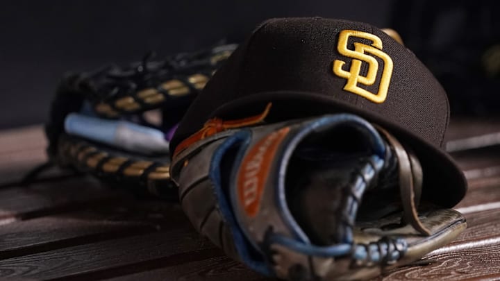Jul 23, 2021; Miami, Florida, USA; A general view of a San Diego Padres hat and glove in the dugout prior to the game between the Miami Marlins and the San Diego Padres at loanDepot park. Mandatory Credit: Jasen Vinlove-Imagn Images