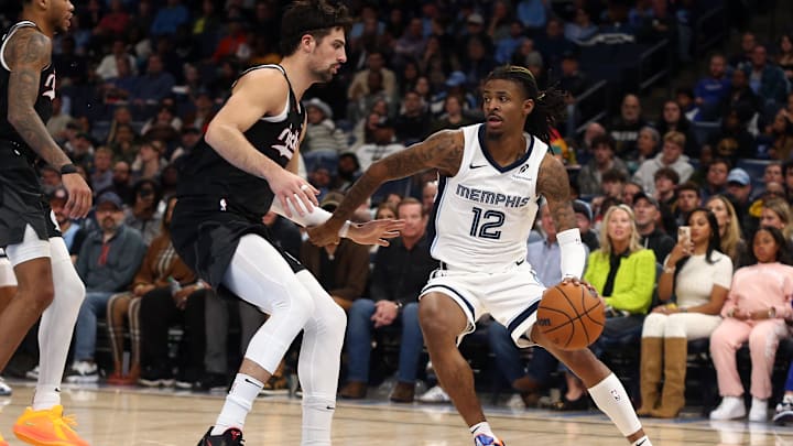 Nov 25, 2024; Memphis, Tennessee, USA; Memphis Grizzlies guard Ja Morant (12) dribbles as Portland Trail Blazers forward Deni Avdija (8) defends during the second half at FedExForum. Mandatory Credit: Petre Thomas-Imagn Images