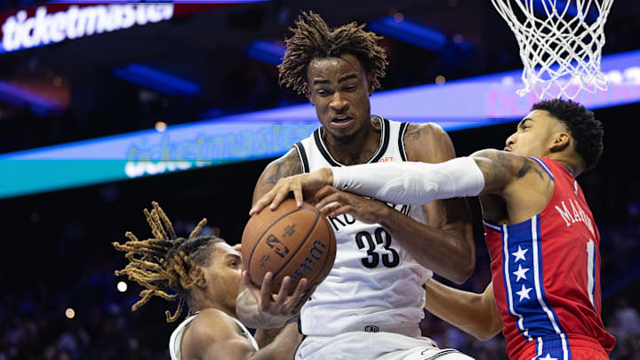Nov 22, 2024; Philadelphia, Pennsylvania, USA; Brooklyn Nets center Nic Claxton (33) grabs a rebound past Philadelphia 76ers forward KJ Martin (1) during the fourth quarter at Wells Fargo Center. Mandatory Credit: Bill Streicher-Imagn Images