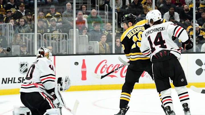 Apr 10, 2025; Boston, Massachusetts, USA; Chicago Blackhawks goaltender Arvid Soderblom (40) makes a save in front of Boston Bruins center John Beecher (19) and defenseman Kevin Korchinski (14) during the third period at TD Garden. Mandatory Credit: Bob DeChiara-Imagn Images