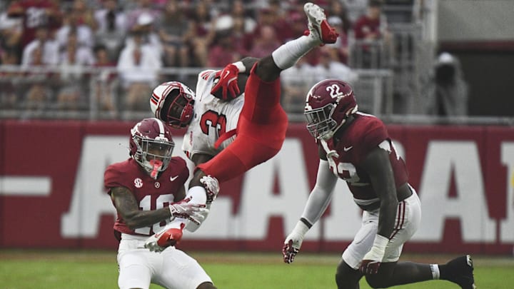 Aug 31, 2024; Tuscaloosa, Alabama, USA;  Western Kentucky Hilltoppers running back Elijah Young (3) is flipped into the air as he is tackled by Alabama Crimson Tide defensive back Red Morgan (16) and defensive lineman LT Overton (22) during the first half at Bryant-Denny Stadium.  Mandatory Credit: Gary Cosby Jr.-USA TODAY Sports