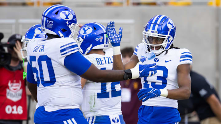Nov 23, 2024; Tempe, Arizona, USA; Brigham Young Cougars wide receiver Jojo Phillips (13) celebrates a touchdown with offensive lineman Isaiah Jatta (50) against the Arizona State Sun Devils at Mountain America Stadium. Mandatory Credit: Mark J. Rebilas-Imagn Images