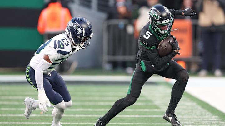 New York Jets wide receiver Garrett Wilson fights for yards as Seattle Seahawks cornerback Josh Jobe defends.