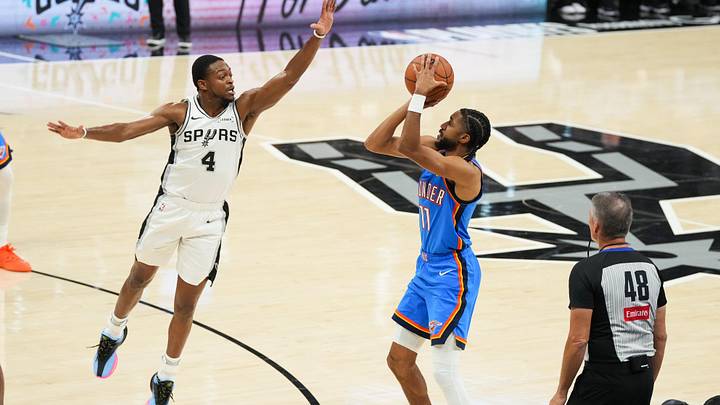 May 24, 2026; San Antonio, Texas, USA; Oklahoma City Thunder guard Isaiah Joe (11) shoots while defended by San Antonio Spurs guard De'Aaron Fox (4) in the first half during game four of the western conference finals for the 2026 NBA playoffs at Frost Bank Center. Mandatory Credit: Scott Wachter-Imagn Images