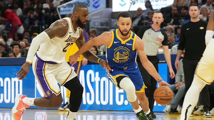 Golden State Warriors guard Steph Curry dribbles against Los Angeles Lakers forward LeBron James
