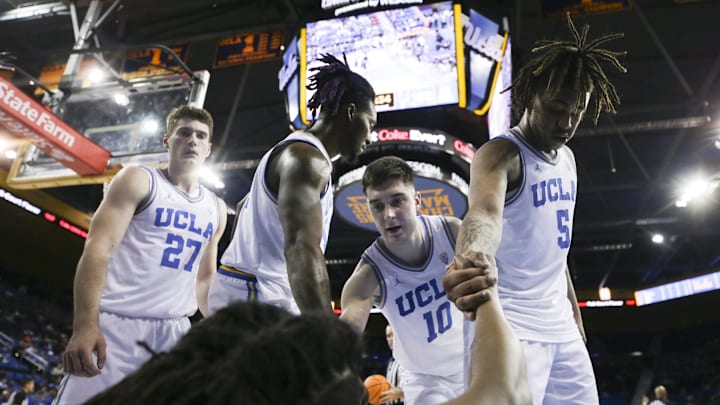 Mar 7, 2024; Los Angeles, California, USA; Members of the UCLA mens basketball team assist UCLA guard Sebastian Mack (12) during the second half of a game against the Arizona Wildcats at Pauley Pavilion presented by Wescom. Mandatory Credit: Yannick Peterhans-Imagn Images