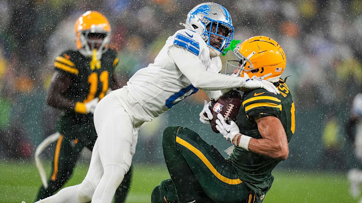 Detroit Lions cornerback Terrion Arnold (0) tackles Green Bay Packers wide receiver Christian Watson (9).