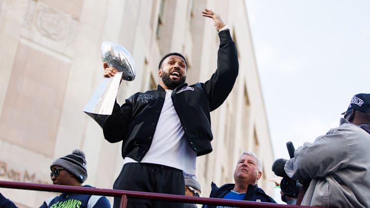 Feb 11, 2026; Seattle, WA, USA;  Seattle Seahawks safety Julian Love (20) celebrates with the Vince Lombardi trophy during the Super Bowl LX parade. Mandatory Credit: Kevin Ng-Imagn Images