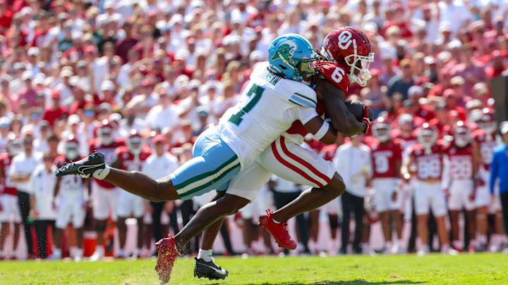 Sep 14, 2024; Norman, Oklahoma, USA;  Oklahoma Sooners wide receiver Deion Burks (6) runs with the ball as Tulane Green Wave safety Caleb Ransaw (7) defends during the first half at Gaylord Family-Oklahoma Memorial Stadium.
