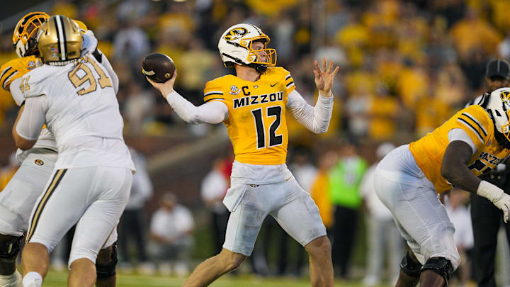 Sep 21, 2024; Columbia, Missouri, USA; Missouri Tigers quarterback Brady Cook (12) throws a touchdown pass against the Vanderbilt Commodores during overtime at Faurot Field at Memorial Stadium. Mandatory Credit: Jay Biggerstaff-Imagn Images