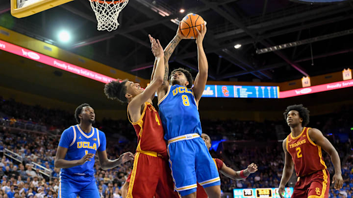 Feb 24, 2026; Los Angeles, California, USA; UCLA Bruins guard Eric Freeny (8) shoots over Southern California Trojans guard Chad Baker-Mazara (4) during the second half at Pauley Pavilion presented by Wescom Financial. Mandatory Credit: Robert Hanashiro-Imagn Images