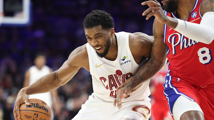 Jan 16, 2026; Philadelphia, Pennsylvania, USA; Cleveland Cavaliers guard Donovan Mitchell (45) drives against Philadelphia 76ers forward Paul George (8) during the fourth quarter at Xfinity Mobile Arena. Mandatory Credit: Bill Streicher-Imagn Images