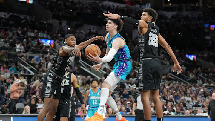 Jan 12, 2024; San Antonio, Texas, USA; Charlotte Hornets guard LaMelo Ball (1) scoops the ball around San Antonio Spurs guard Blake Wesley (14) and forward Dominick Barlow (26) in the first half at Frost Bank Center. Mandatory Credit: Daniel Dunn-Imagn Images Jan 12, 2024; San Antonio, Texas, USA; Charlotte Hornets guard LaMelo Ball (1) scoops the ball around San Antonio Spurs guard Blake Wesley (14) and forward Dominick Barlow (26) in the first half at Frost Bank Center. Mandatory Credit: Daniel Dunn-Imagn Images