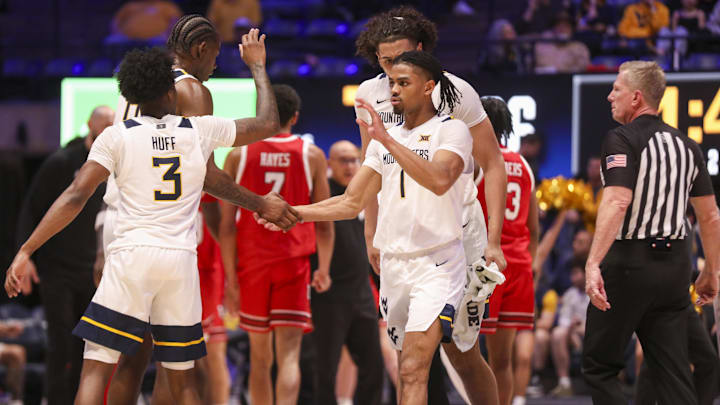 Feb 18, 2026; Morgantown, West Virginia, USA; West Virginia Mountaineers guard Jasper Floyd (1) celebrates with teammates during the second half against the Utah Utes at Hope Coliseum. Mandatory Credit: Ben Queen-Imagn Images
