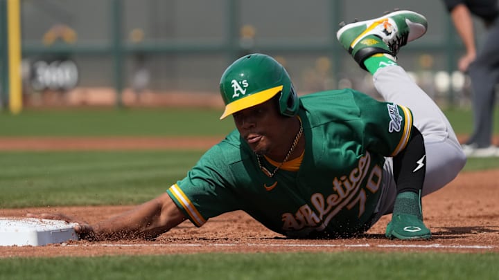 Feb 23, 2026; Scottsdale, Arizona, USA; Athletics center fielder Junior Perez (70) dives back to first against the San Francisco Giants in the first inning at Scottsdale Stadium. Mandatory Credit: Rick Scuteri-Imagn Images