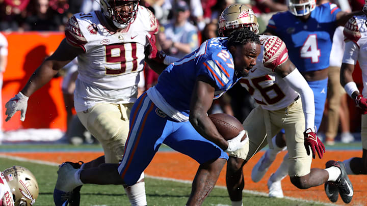Florida Gators running back Dameon Pierce (27) runs with the ball after getting this helmet knocked