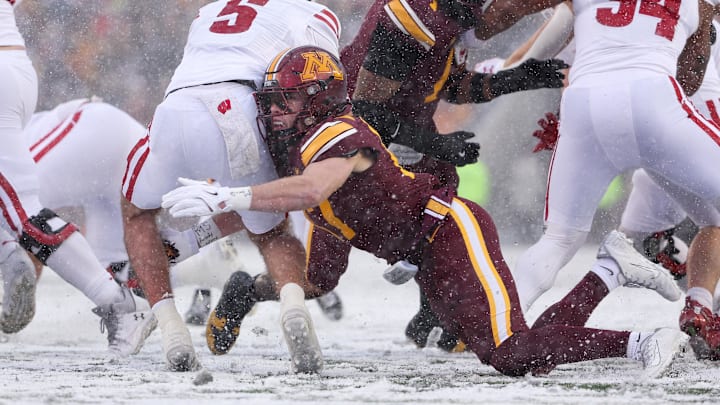 Nov 29, 2025; Minneapolis, Minnesota, USA; Minnesota Golden Gophers defensive back John Nestor (17) tackles Wisconsin Badgers quarterback Carter Smith (5) during the first half at Huntington Bank Stadium. Mandatory Credit: Matt Krohn-Imagn Images