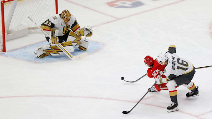 Mar 4, 2026; Detroit, Michigan, USA;  Detroit Red Wings center Dylan Larkin (71) takes a shot on Vegas Golden Knights goaltender Adin Hill (33) defended by right wing Pavel Dorofeyev (16) in the first period at Little Caesars Arena. Mandatory Credit: Rick Osentoski-Imagn Images