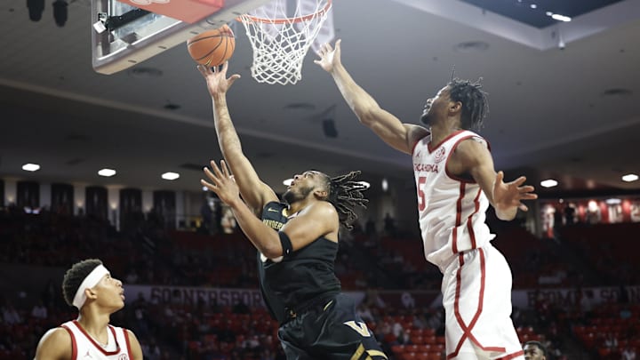 Feb 1, 2025; Norman, Oklahoma, USA; Vanderbilt Commodores forward Devin McGlockton (99) goes up for a basket between Oklahoma Sooners guard Jeremiah Fears (0) and forward Mohamed Wague (5) during the first half at Lloyd Noble Center. Mandatory Credit: Alonzo Adams-Imagn Images