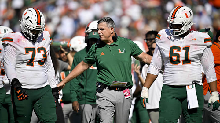 Nov 1, 2025; Dallas, Texas, USA; Miami Hurricanes head coach Mario Cristobal talks to offensive lineman Anez Cooper (73) and offensive lineman Francis Mauigoa (61) during the second half against the SMU Mustangs at Gerald J. Ford Stadium. Mandatory Credit: Jerome Miron-Imagn Images Nov 1, 2025; Dallas, Texas, USA; Miami Hurricanes head coach Mario Cristobal talks to offensive lineman Anez Cooper (73) and offensive lineman Francis Mauigoa (61) during the second half against the SMU Mustangs at Gerald J. Ford Stadium. Mandatory Credit: Jerome Miron-Imagn Images
