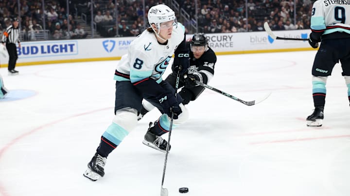 Apr 7, 2025; Los Angeles, California, USA;  Seattle Kraken defenseman Cale Fleury (8) skates with the puck against Los Angeles Kings left wing Trevor Moore (12) during the second period at Crypto.com Arena. Mandatory Credit: Kiyoshi Mio-Imagn Images