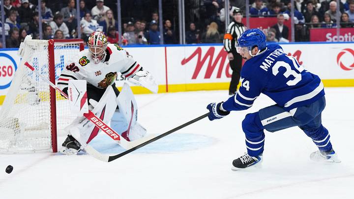 Dec 16, 2025; Toronto, Ontario, CAN; Toronto Maple Leafs center Auston Matthews (34) tries to play the puck in front of Chicago Blackhawks goaltender Spencer Knight (30) during the first period at Scotiabank Arena. Mandatory Credit: Nick Turchiaro-Imagn Images