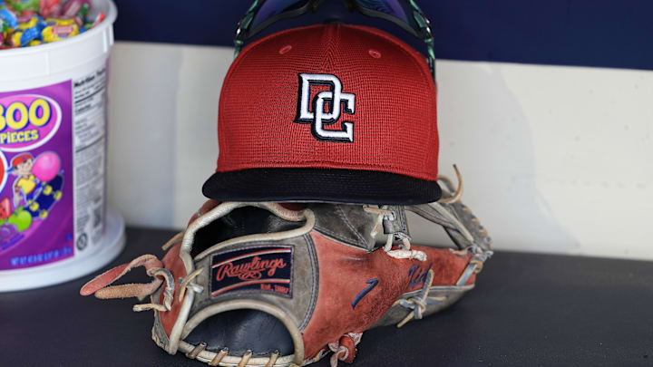 Jul 12, 2024; Milwaukee, Wisconsin, USA;  An Washington Nationals hat and glove sit in the dugout during batting practice prior to the game against the Milwaukee Brewers at American Family Field. 