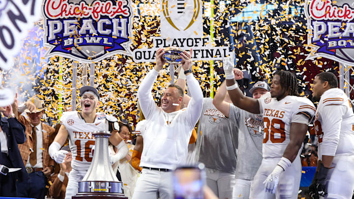 Jan 1, 2025; Atlanta, GA, USA; Texas Longhorns head coach Steve Sarkisian and defensive back Michael Taaffe (16) and linebacker Barryn Sorrell (88) and offensive lineman Kelvin Banks Jr. (78) hold up the trophy after a victory over the Arizona State Sun Devils in the Peach Bowl at Mercedes-Benz Stadium. Mandatory Credit: Brett Davis-Imagn Images
