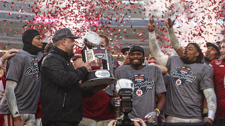 Nebraska coach Matt Rhule holds the championship trophy as Nebraska players celebrate after the game against Boston College. Nebraska coach Matt Rhule holds the championship trophy as Nebraska players celebrate after the game against Boston College.