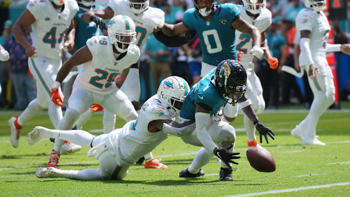 Sep 8, 2024; Miami Gardens, Florida, USA; Miami Dolphins safety Jevon Holland (8) punches the ball away from Jacksonville Jaguars running back Travis Etienne Jr. (1) causing a fumble that was recovered by the Dolphins in the end zone during the third quarter at Hard Rock Stadium. Sep 8, 2024; Miami Gardens, Florida, USA; Miami Dolphins safety Jevon Holland (8) punches the ball away from Jacksonville Jaguars running back Travis Etienne Jr. (1) causing a fumble that was recovered by the Dolphins in the end zone during the third quarter at Hard Rock Stadium.
