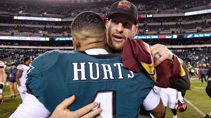 Philadelphia Eagles quarterback Jalen Hurts (1) hugs Washington Commanders injured quarterback Carson Wentz after the game at Lincoln Financial Field.