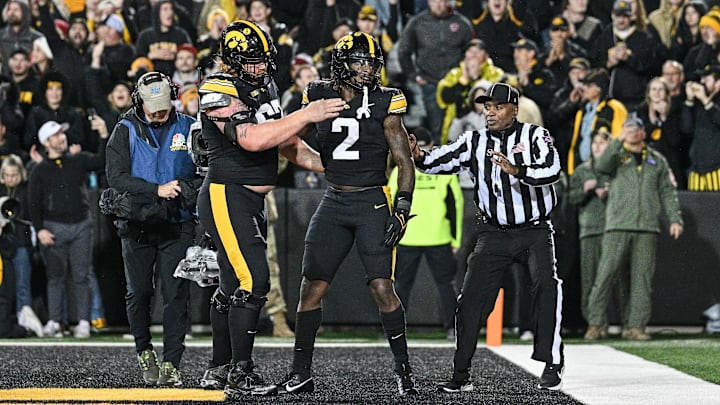 Nov 2, 2024; Iowa City, Iowa, USA; Iowa Hawkeyes offensive lineman Gennings Dunker (67) and running back Kaleb Johnson (2) react after a touchdown run by Johnson against the Wisconsin Badgers during the fourth quarter at Kinnick Stadium. Mandatory Credit: Jeffrey Becker-Imagn Images