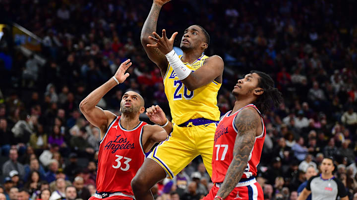 Feb 4, 2025; Inglewood, California, USA; Los Angeles Lakers guard Shake Milton (20) shoots against Los Angeles Clippers forward Nicolas Batum (33) and guard Kevin Porter Jr. (77) uring the second half at Intuit Dome. Mandatory Credit: Gary A. Vasquez-Imagn Images